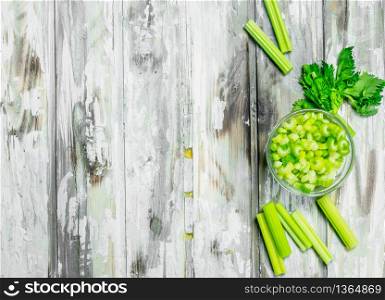 Pieces of celery in a bowl. On wooden background. Pieces of celery in a bowl.