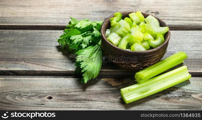Pieces of celery in a bowl. On wooden background. Pieces of celery in a bowl.