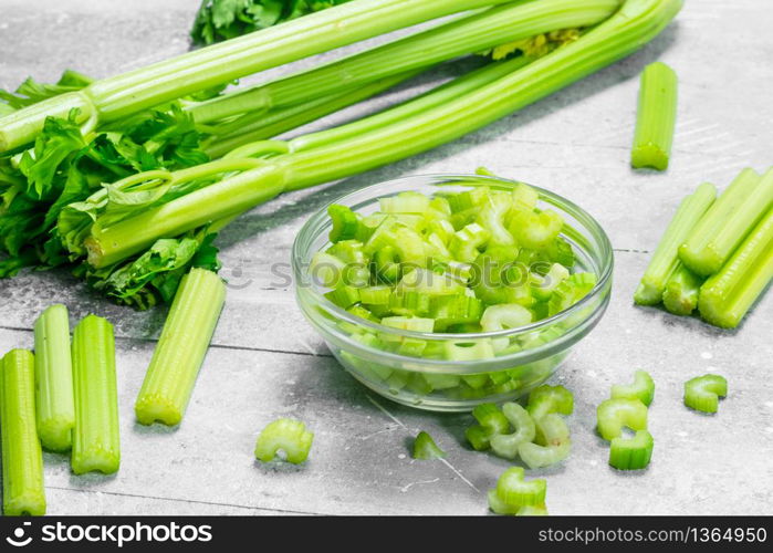 Pieces of celery in a glass bowl. On rustic background. Pieces of celery in a glass bowl.