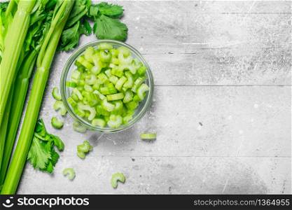 Pieces of celery in a glass bowl. On rustic background. Pieces of celery in a glass bowl.