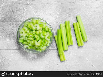 Pieces of celery in a glass bowl. On rustic background. Pieces of celery in a glass bowl.