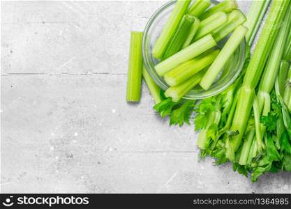 Pieces of celery in a glass bowl. On white rustic background. Pieces of celery in a glass bowl.