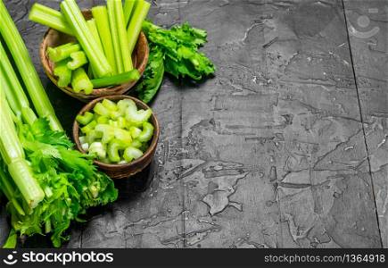 Pieces of celery in a wooden bowl. On rustic background. Pieces of celery in a wooden bowl.