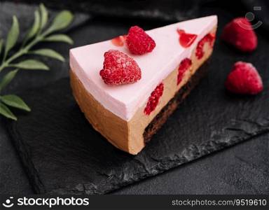 Pieces of cheesecake with raspberries on black board