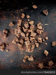 Pieces of dark chocolate. Top view. On a rustic background. . Pieces of dark chocolate. Top view.