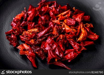 Pieces of dried paprika, preparation of powder spice for various dishes, against a dark concrete background. Pieces of dried paprika, preparation of powder spice for various dishes