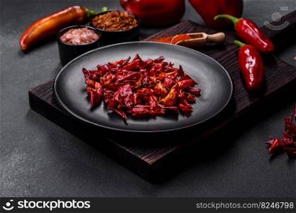 Pieces of dried paprika, preparation of powder spice for various dishes, against a dark concrete background. Pieces of dried paprika, preparation of powder spice for various dishes