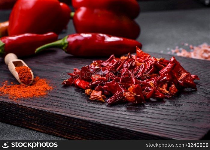 Pieces of dried paprika, preparation of powder spice for various dishes, against a dark concrete background. Pieces of dried paprika, preparation of powder spice for various dishes