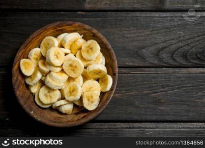 Pieces of fresh bananas in a wooden plate. On a wooden background.. Pieces of fresh bananas in a wooden plate.