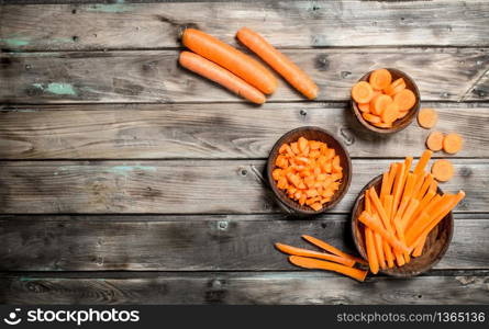 Pieces of fresh carrots on a bowl. On wooden background. Pieces of fresh carrots on a bowl.