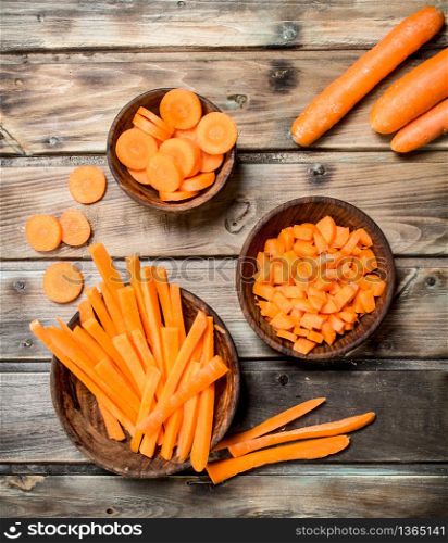 Pieces of fresh carrots on a bowl. On wooden background. Pieces of fresh carrots on a bowl.