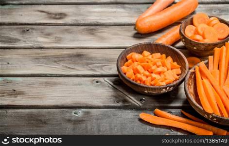 Pieces of fresh carrots on a bowl. On wooden background. Pieces of fresh carrots on a bowl.