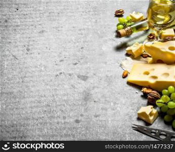 Pieces of fresh cheese with white wine and nuts. On the stone table.. Pieces of fresh cheese with white wine and nuts.