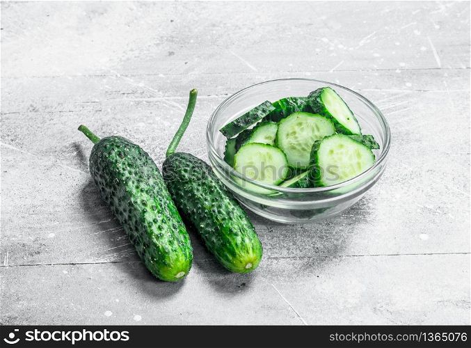 Pieces of fresh cucumbers in a glass bowl. On rustic background. Pieces of fresh cucumbers in a glass bowl.