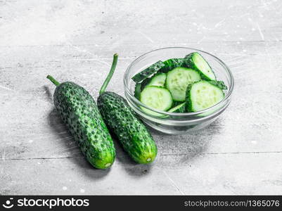 Pieces of fresh cucumbers in a glass bowl. On rustic background. Pieces of fresh cucumbers in a glass bowl.