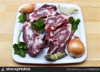 Pieces of fresh lamb on the plate . Delicious fat-tailed lamb with onion on the plate . Meat to be grilled.. Pieces of fresh lamb on the plate . Delicious fat-tailed lamb with onion on the plate . Meat to be grilled