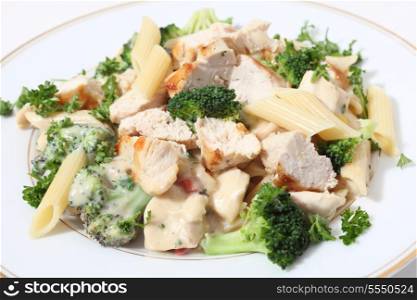 Pieces of grilled chicken served with penne pasta in a broccoli, capsicum and garlic cheese sauce, garnished with parsley.