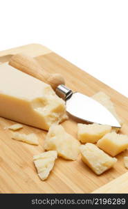 pieces of Parmesan cheese on wooden cutting board. white background. pieces of Parmesan cheese on wooden cutting board