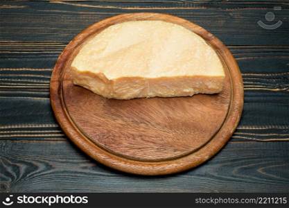 pieces of parmesan or parmigiano hard cheese on wooden cutting board. pieces of parmesan or parmigiano cheese