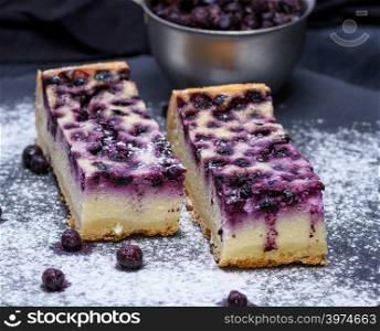 pieces of pie from cottage cheese and blueberries on a black background