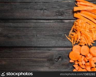 Pieces of ripe carrots. On black wooden background. Pieces of ripe carrots.