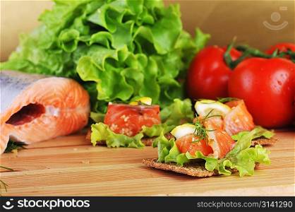 pieces of salmon with lemon lettuce and small loafs