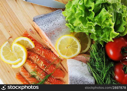 pieces of salmon with spice on wooden plate