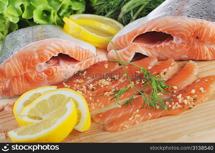 pieces of salmon with spice on wooden plate