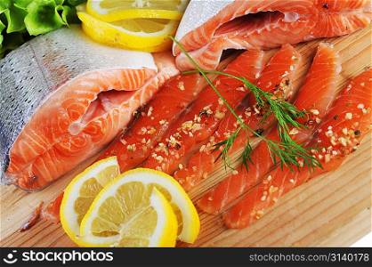 pieces of salmon with spice on wooden plate