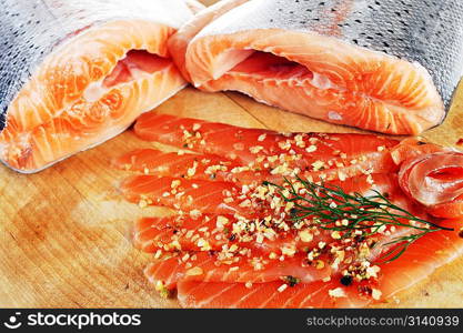 pieces of salmon with spice on wooden plate
