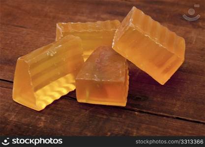 pieces of semitransparent handmade lemongrass soap against old scratched wooden background