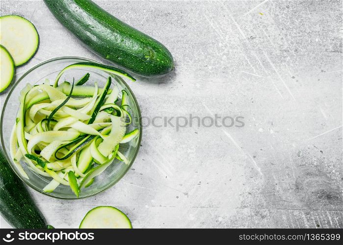 Pieces of zucchini in a glass bowl. On rustic background. Pieces of zucchini in a glass bowl.