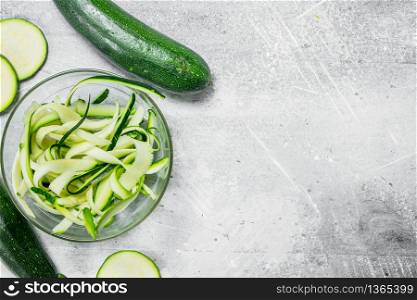 Pieces of zucchini in a glass bowl. On rustic background. Pieces of zucchini in a glass bowl.