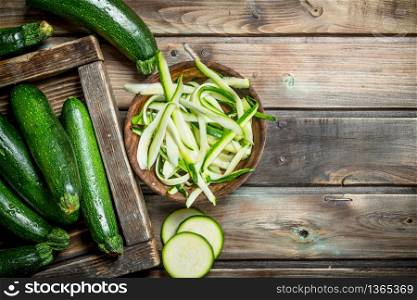 Pieces of zucchini in bowl. On wooden background. Pieces of zucchini in bowl.