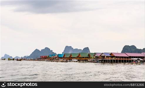 Pier and restaurants floating over the sea at Punyi Island or Koh Panyee during a boat tour in the Ao Phang Nga Bay National Park, Thailand, 16:9 wide screen