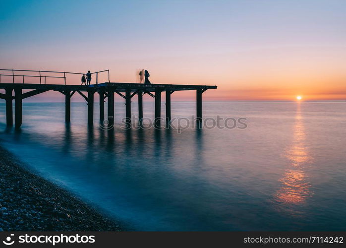 Pier into the sea. Beautiful evening on the beach, Sunrise with orange color and long exposure sea waves. Georgia, Batumi, Adjara