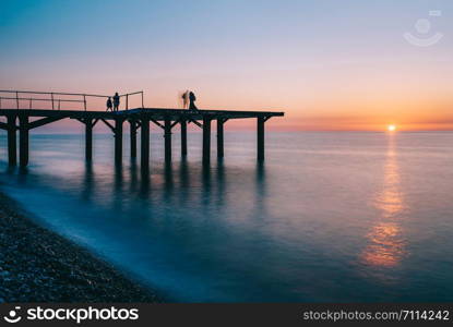 Pier into the sea. Beautiful evening on the beach, Sunrise with orange color and long exposure sea waves. Georgia, Batumi, Adjara