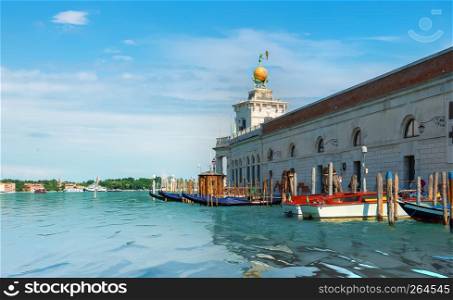 Pier with moored gondolas and boats near basilica of Santa Maria della Salute, Venice