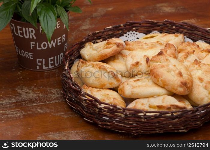 pies in a wicker basket and flower on old wooden table. pies in a wicker basket