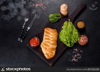 Pies with cabbage. Homemade baking. Traditional Ukrainian cuisine. Close-up. Traditional Ukrainian cabbage pie on a dark concrete background. Baked homemade pie with cabbage
