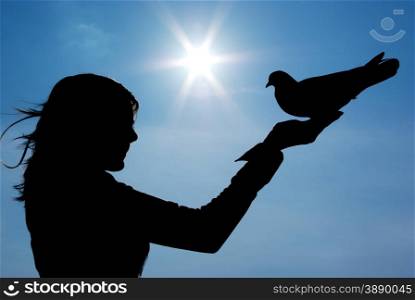 Pigeon sits on girl hand. Conceptual scene.