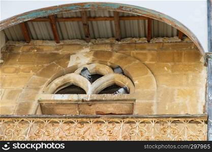 Pigeons use the balcony of an old abandoned house in the historic center of the city of Nicosia, Cyprus as a shelter