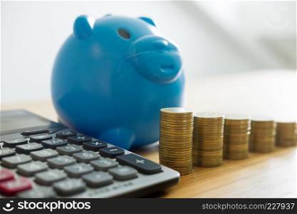Piggy bank and stack of coin money tower with chart data on working table business investment growth finance saving money concept.