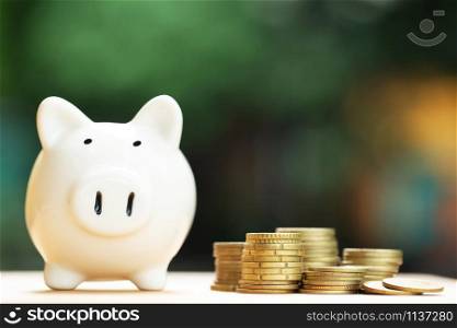 piggy bank family and money coin stacked on each other in different position on the wooden table. savings expenses for loans cost and payment. Credit financial growing business concept. many three pig