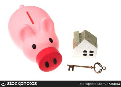 Piggy bank, key and house model isolated on white