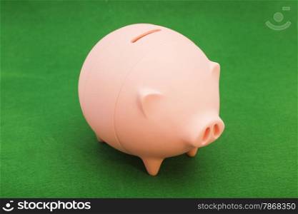 Piggy bank on green background