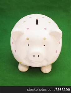 Piggy bank on green background