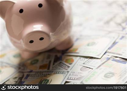 Piggy Bank On Pile on United States One Hundred Dollar Bills.