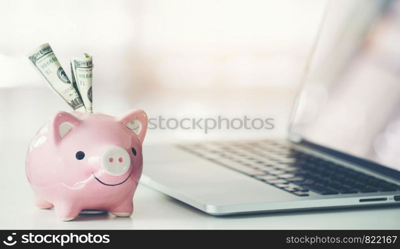 piggy bank with laptop on the desk, online shopping concept