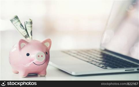 piggy bank with laptop on the desk, online shopping concept